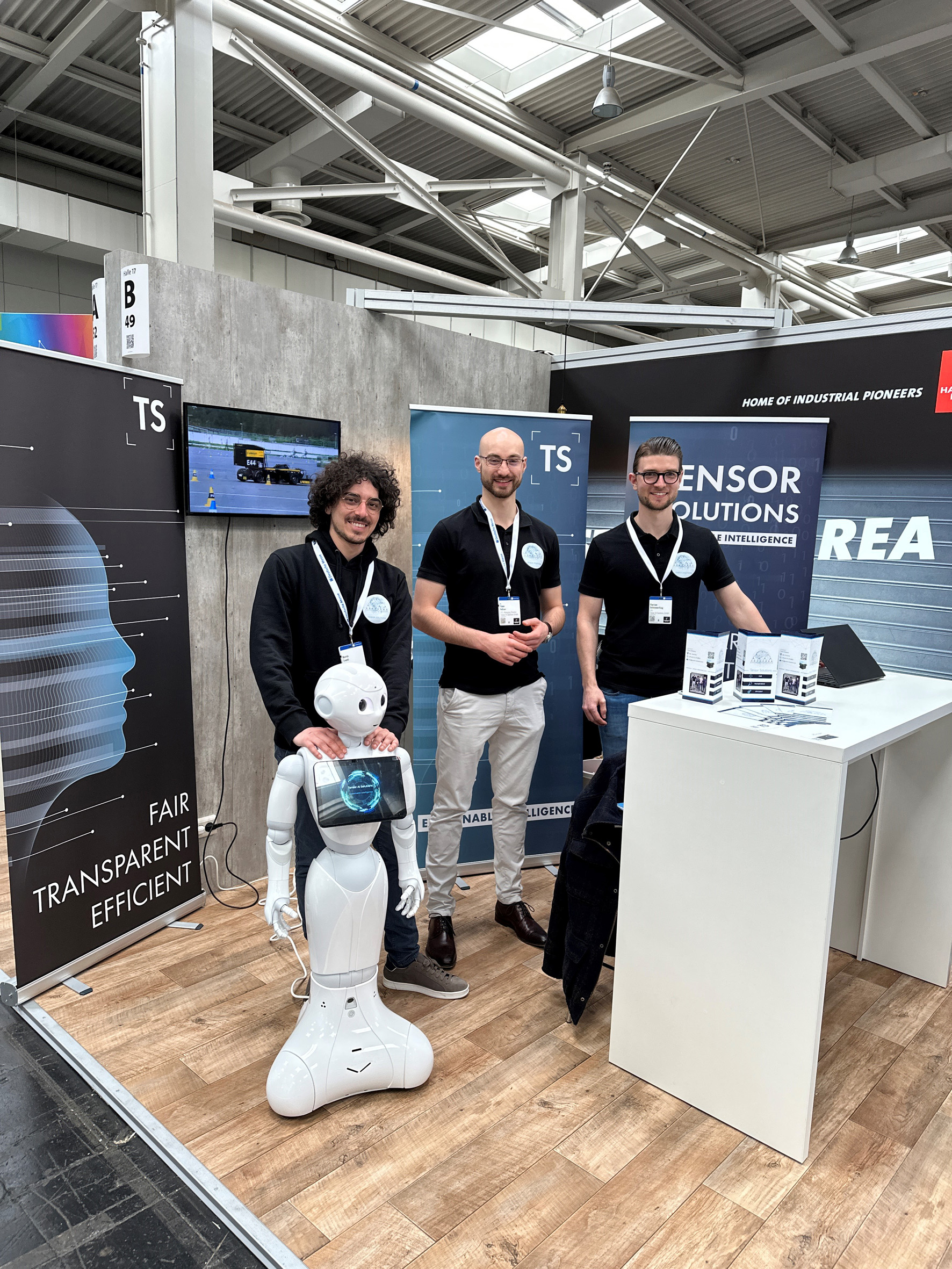 Tensor Solutions HMI (Foto: Tensor AI Solutions): v.l. Marco Trenti, Dr. Timo Felser, Florian Schinnerling mit dem Roboter Tenso