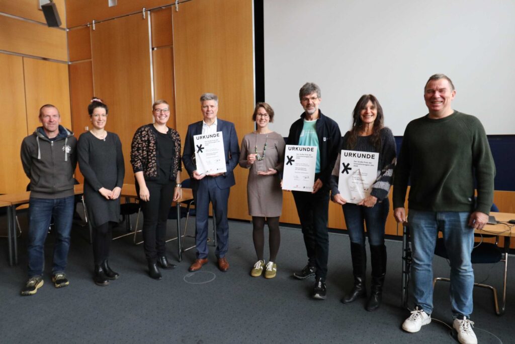 Die Sieger des Großen Preis der Innovationsregion Ulm 2025 mit ihren Trophäen und Urkunden sowie die Ehrenden: Die Sieger und die Ehrenden (v.l.): Bernd Hummel (Einstein-Marathon), Hannah-Sophie Schalanda (Innovationsregion Ulm), Eva Treu (Landrätin Landkreis Neu-Ulm), Frank Schlagenhauf (Gold Ochsen), Meike Traub (Hochschulsportbüro der Universität Ulm), Thomas Zemmler (Universitätsklinikum Ulm), Manuela Seitter (Rockn Woll), Markus Ebner (Einstein-Marathon) 