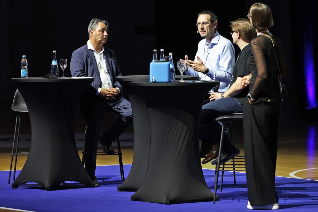 Mehrere Personen sitzen bei einer Podiumsdiskussion.